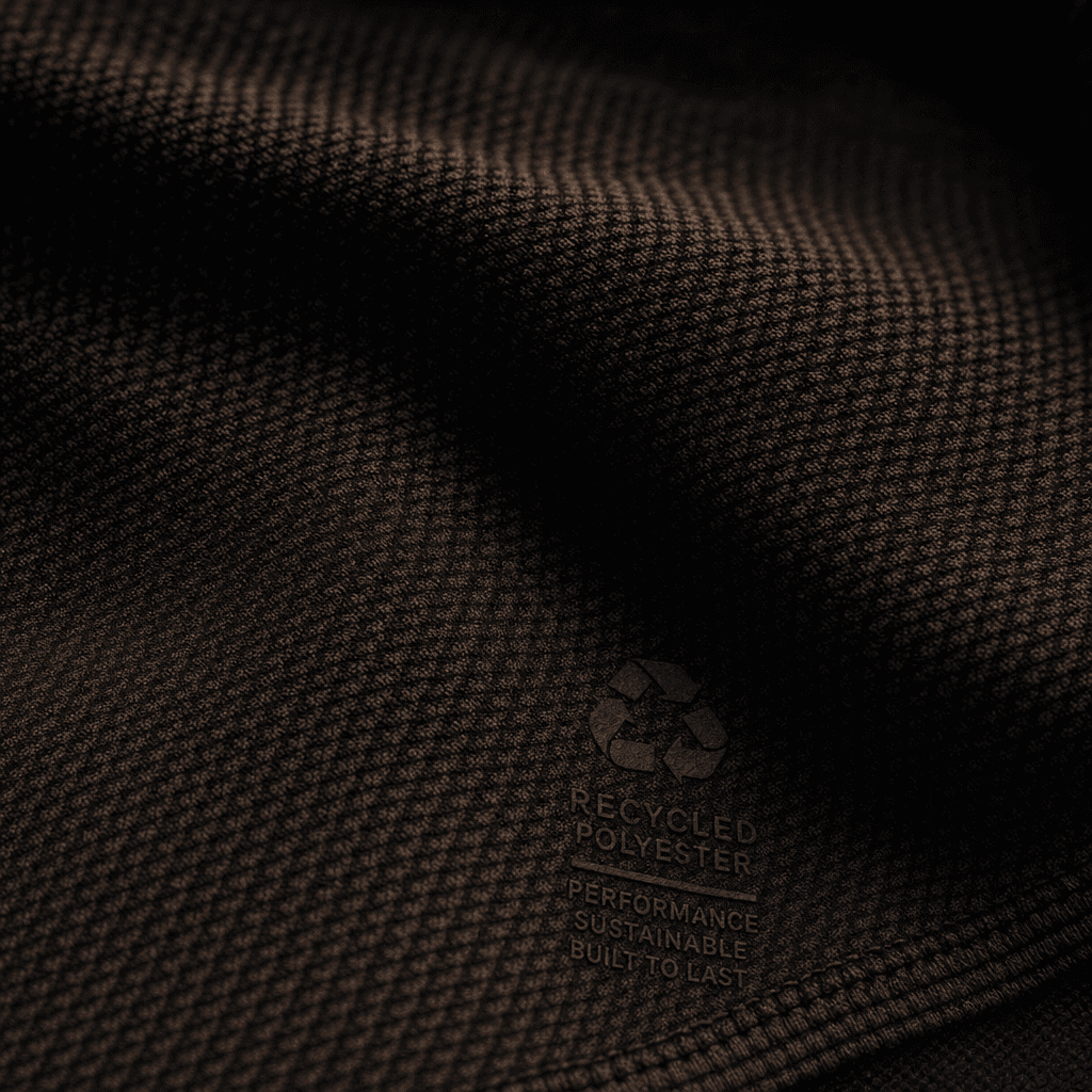 Close-up of recycled fabric texture showing weave and sheen on dark green athletic top